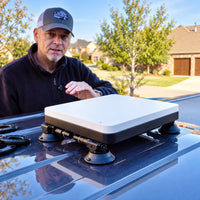 Starlink Mini in an AeroLinkGear protective case mounted on a vehicle roof with four suction-cup arms.
