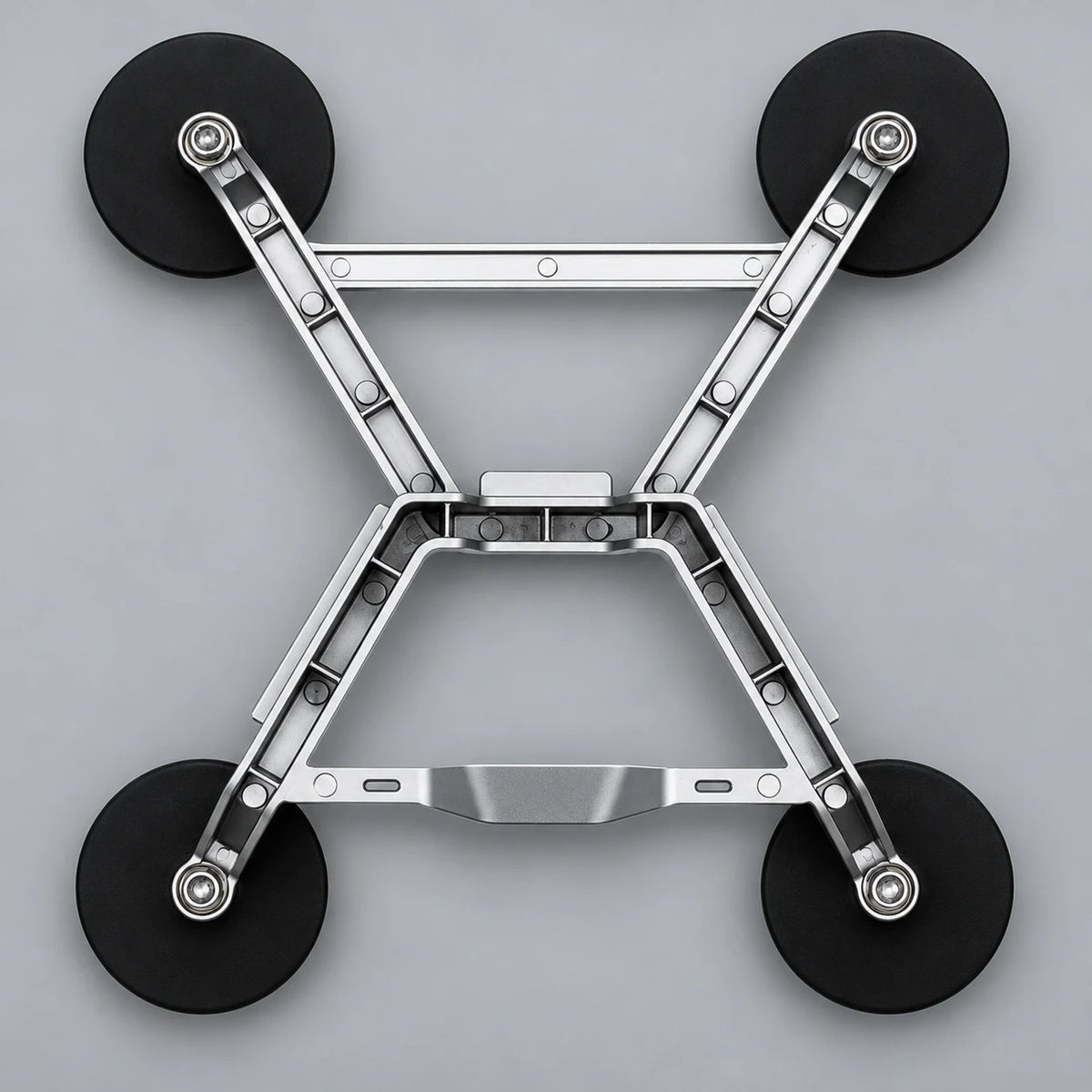 Underside of the aluminum X-frame bracket showing four rubber-wrapped magnetic feet